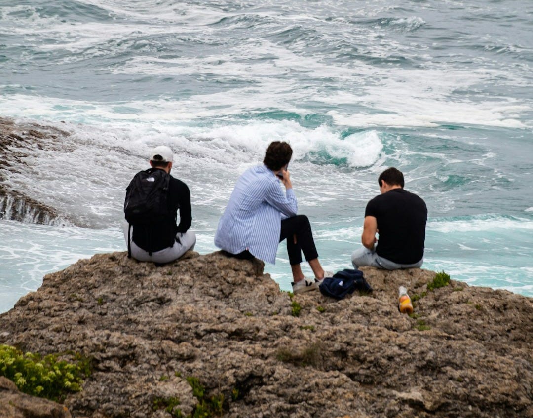 A group of people on a beach next to the ocean