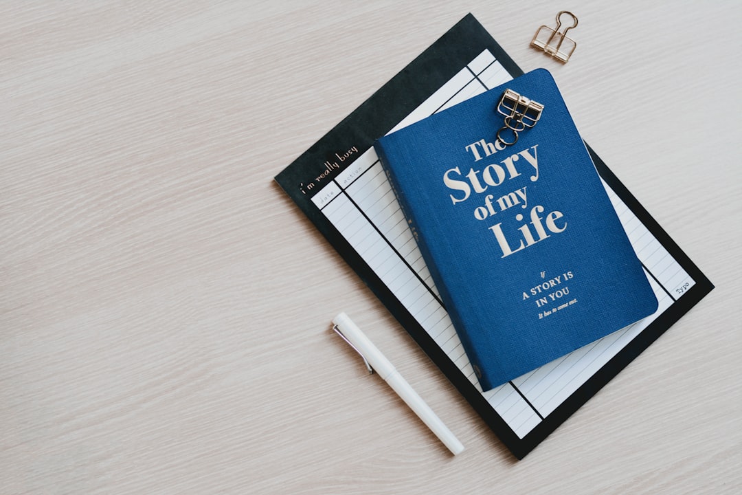 A blue book on a wooden table — the story clients write about themselves before they exit.